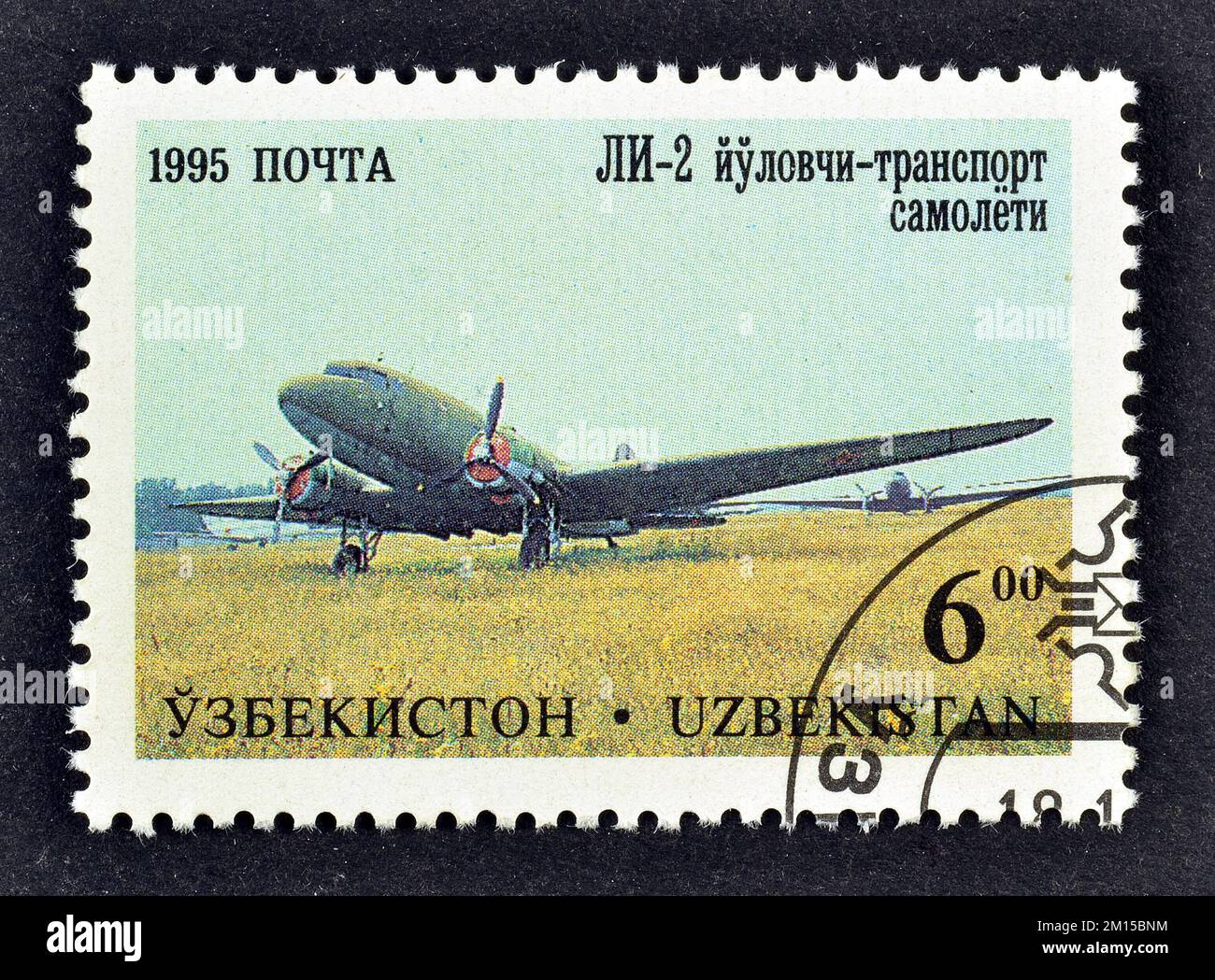 Cancelled postage stamp printed by Uzbekistan, that shows Lisunov Li-2 Airliner, Aircraft of Tashkent's (V.P. Chkalov) Aircraft Factory, circa 1995. Stock Photo