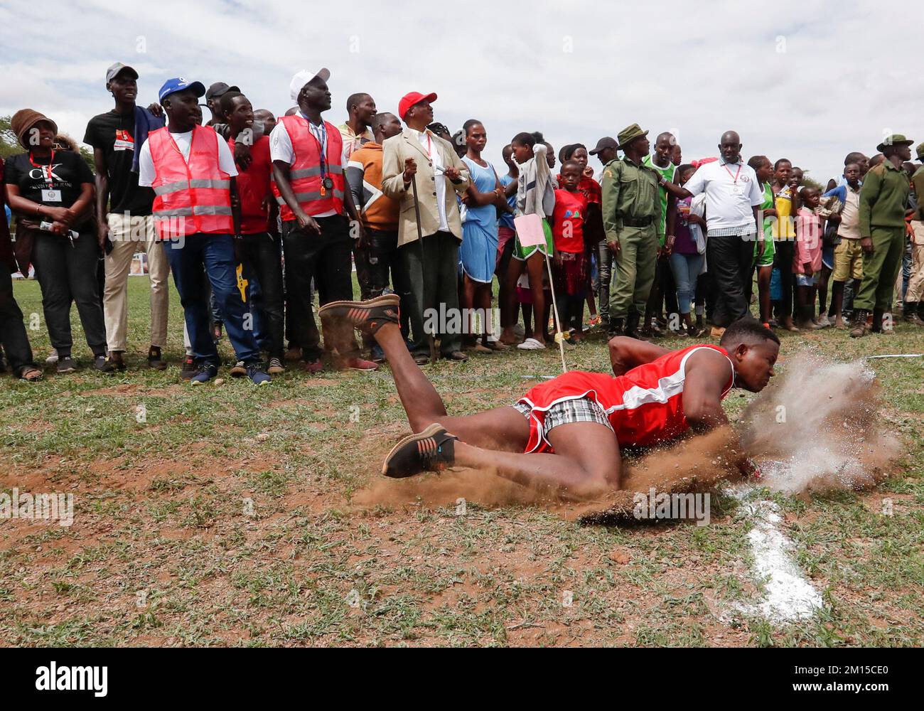 A Maasai Moran falls after throwing a javelin as he competes in in a social sporting event dubbed the Maasai Olympics to offer the warriors an alternative to killing lions as part of their traditional rite of passage, in the Kimana sanctuary, at the base of Mt. Kilimanjaro, near the Kenya-Tanzania border in Kimana, Kajiado, Kenya December 10, 2022. REUTERS/Thomas Mukoya Stock Photo