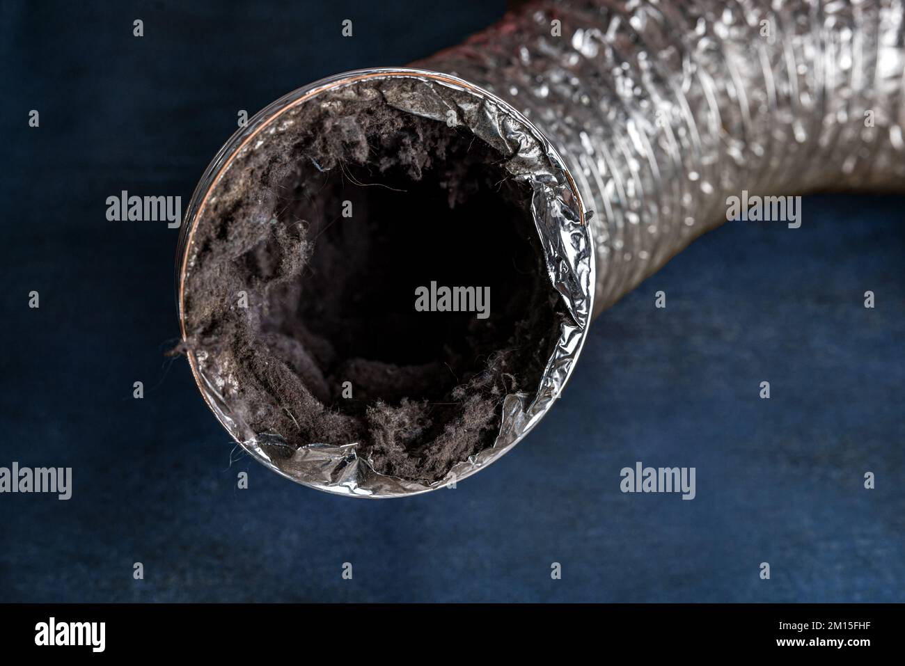 A dirty laundry flexible aluminum dryer vent duct ductwork filled with lint, dust and dirt