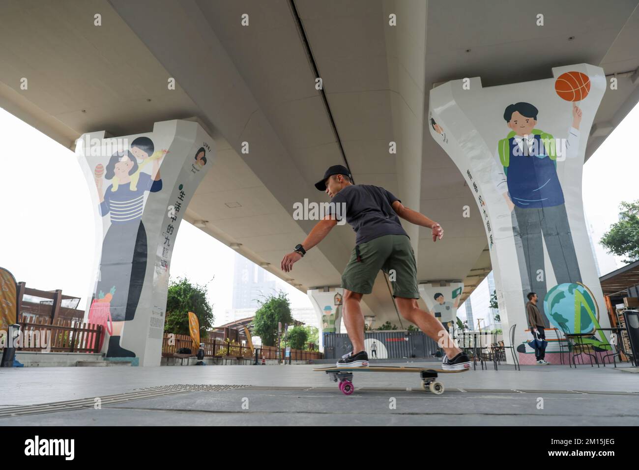 A skateboarder playing skateboard beside murals under a flyover at Kwun Tong  Promenade in Kwun Tong. Hong Kong government committed to enhancing the  streetscape of the city through greening, design and selection
