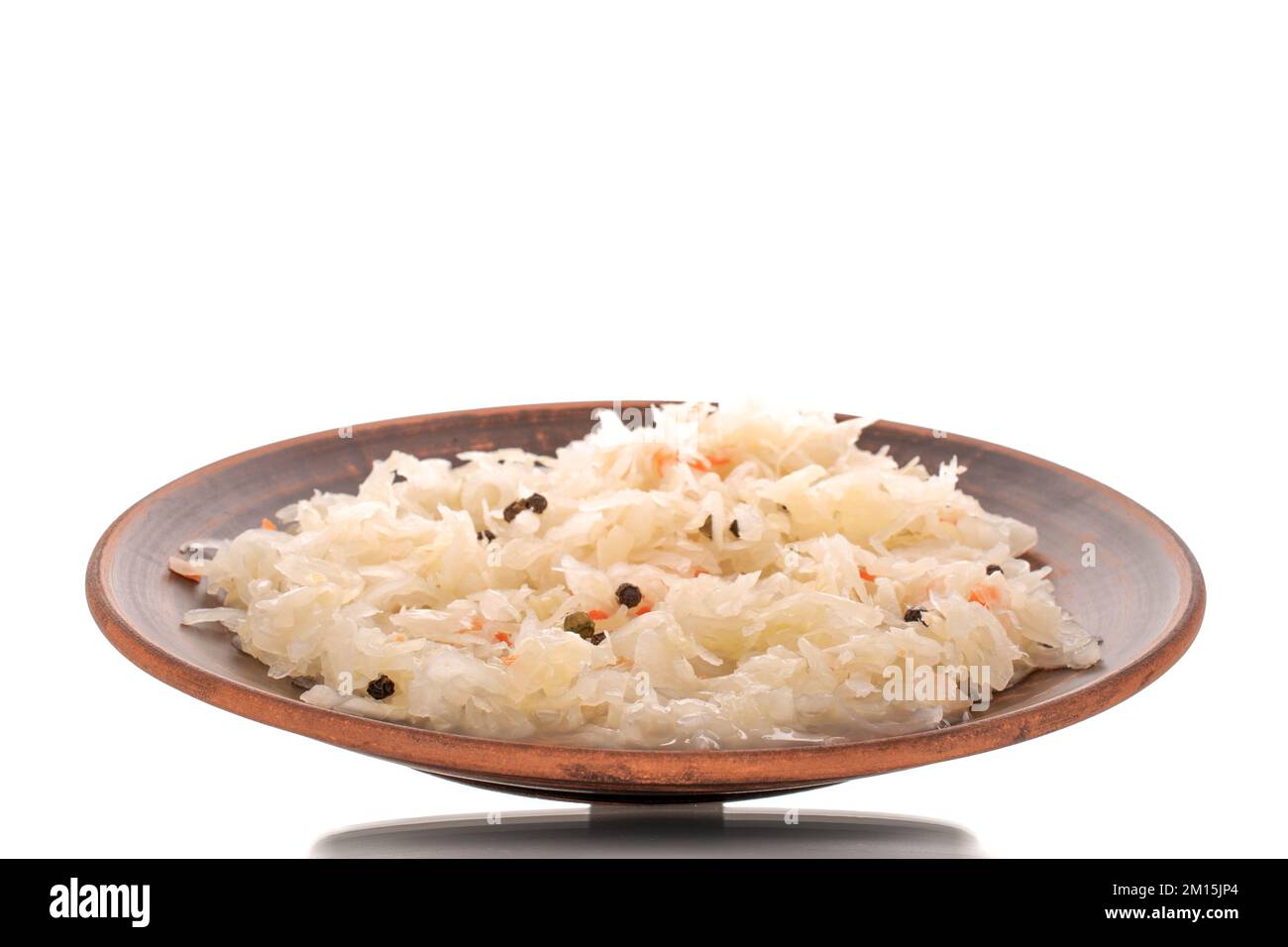 Sauerkraut in a clay plate, macro, isolated on white background Stock