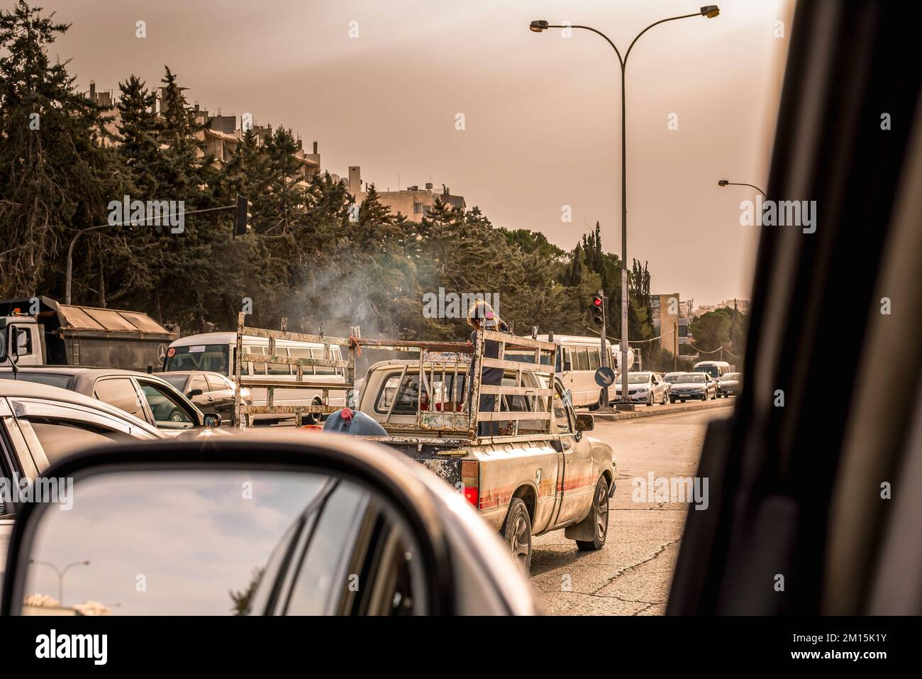 Amman, Jordan - Thursday, February 06 2018 girl in pick up truck car traffic at sunset in amman streets, view from inside the car Stock Photo