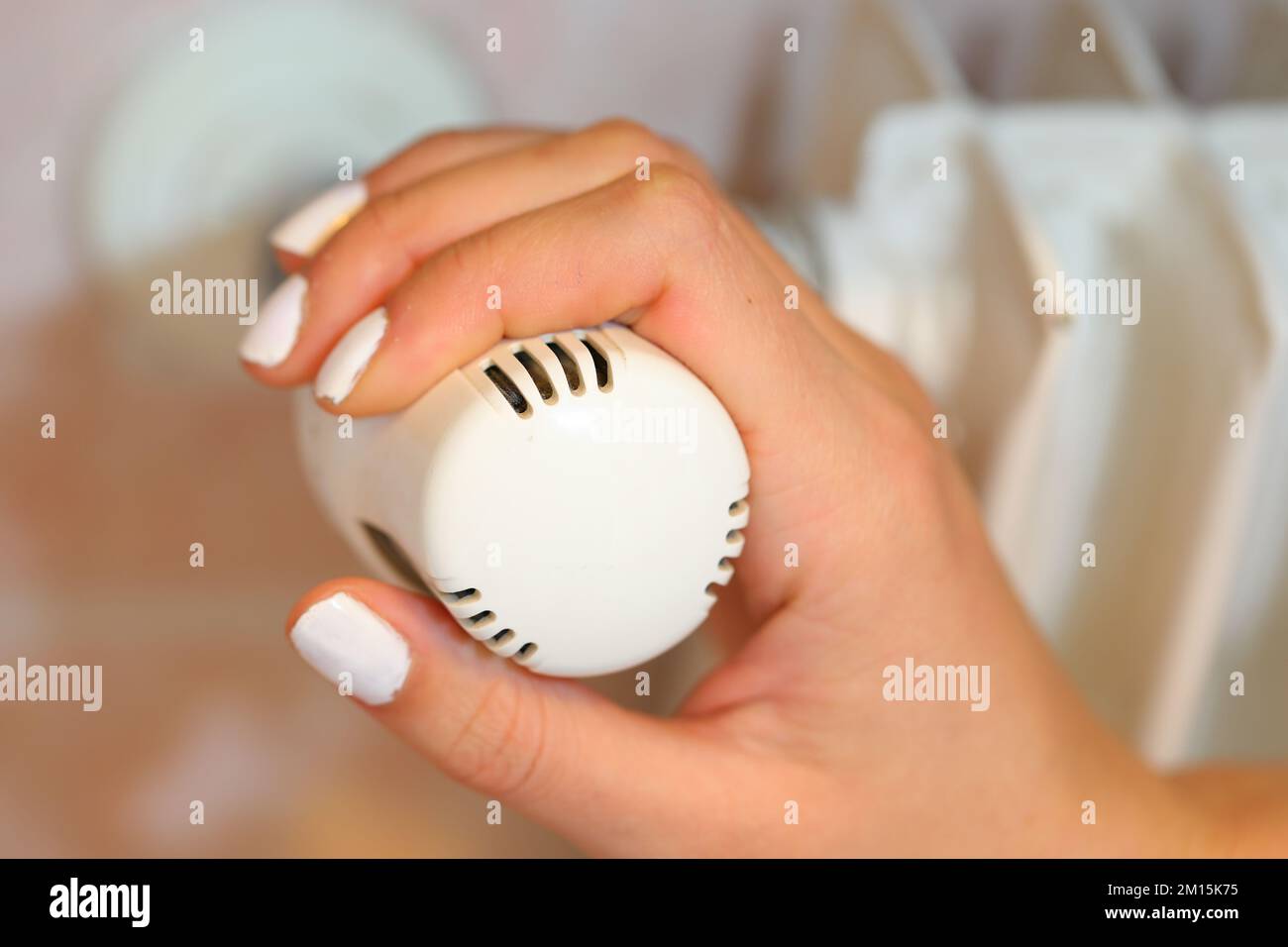 Hand regulating the white Thermostatic Valve for setting the