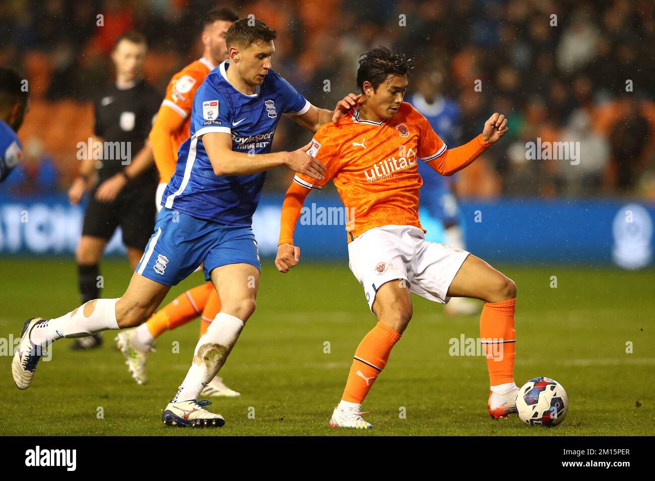 Birmingham City's Krystian Bielik (left) and Blackpool's Kenny Dougall battle for the ball during the Sky Bet Championship match at Bloomfield Road, Blackpool. Picture date: Saturday December 10, 2022. Stock Photo