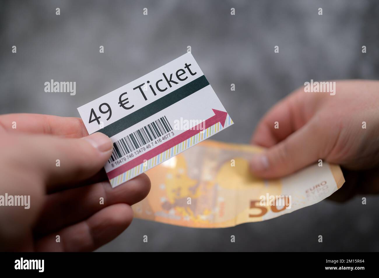 Hands exchanging proposed new germany wide 49 Euro Ticket for 50 euro