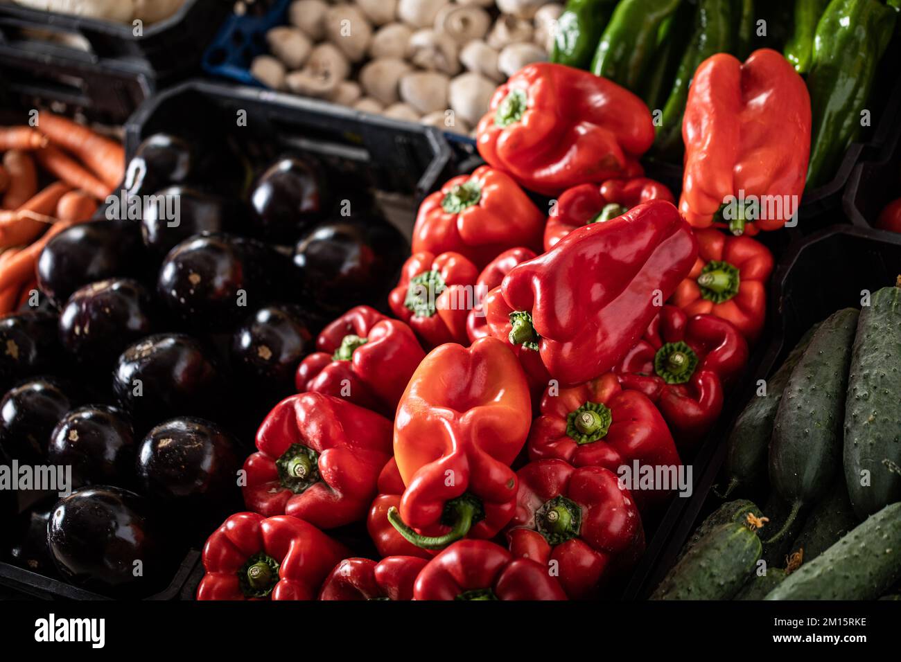 From above of ripe bell peppers cucumbers carrots and mushrooms placed on stall in local market Stock Photo