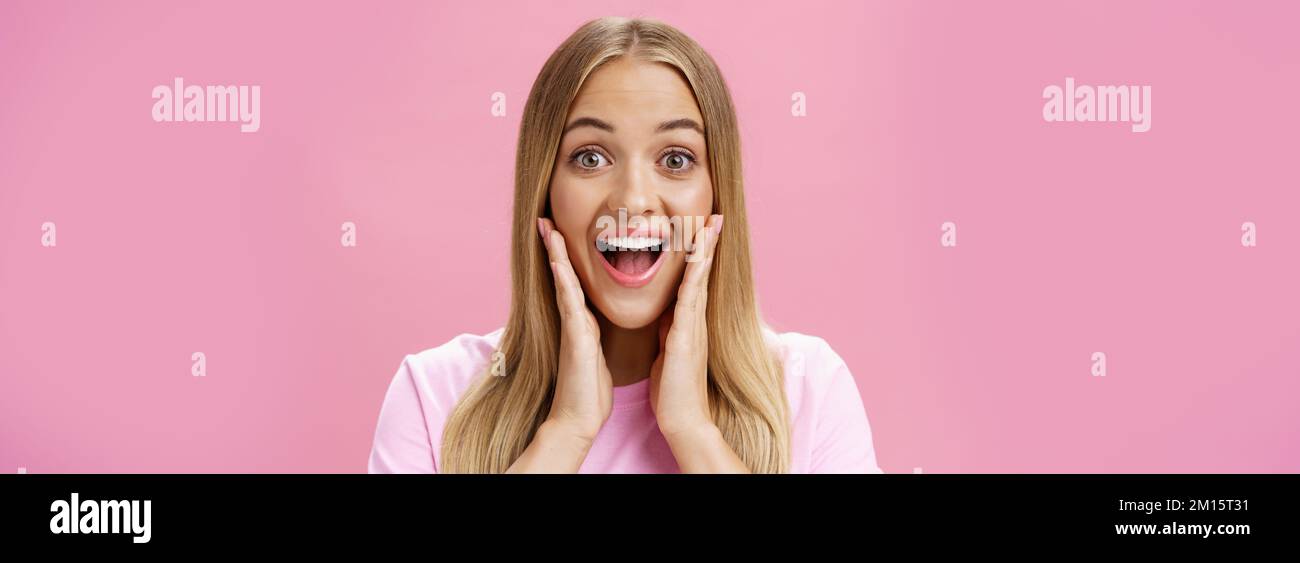 Woman surprised to see own face without imperfactions treating acne feeling beautiful and happy touching cheeks, smiling amazed, joyful looking with Stock Photo