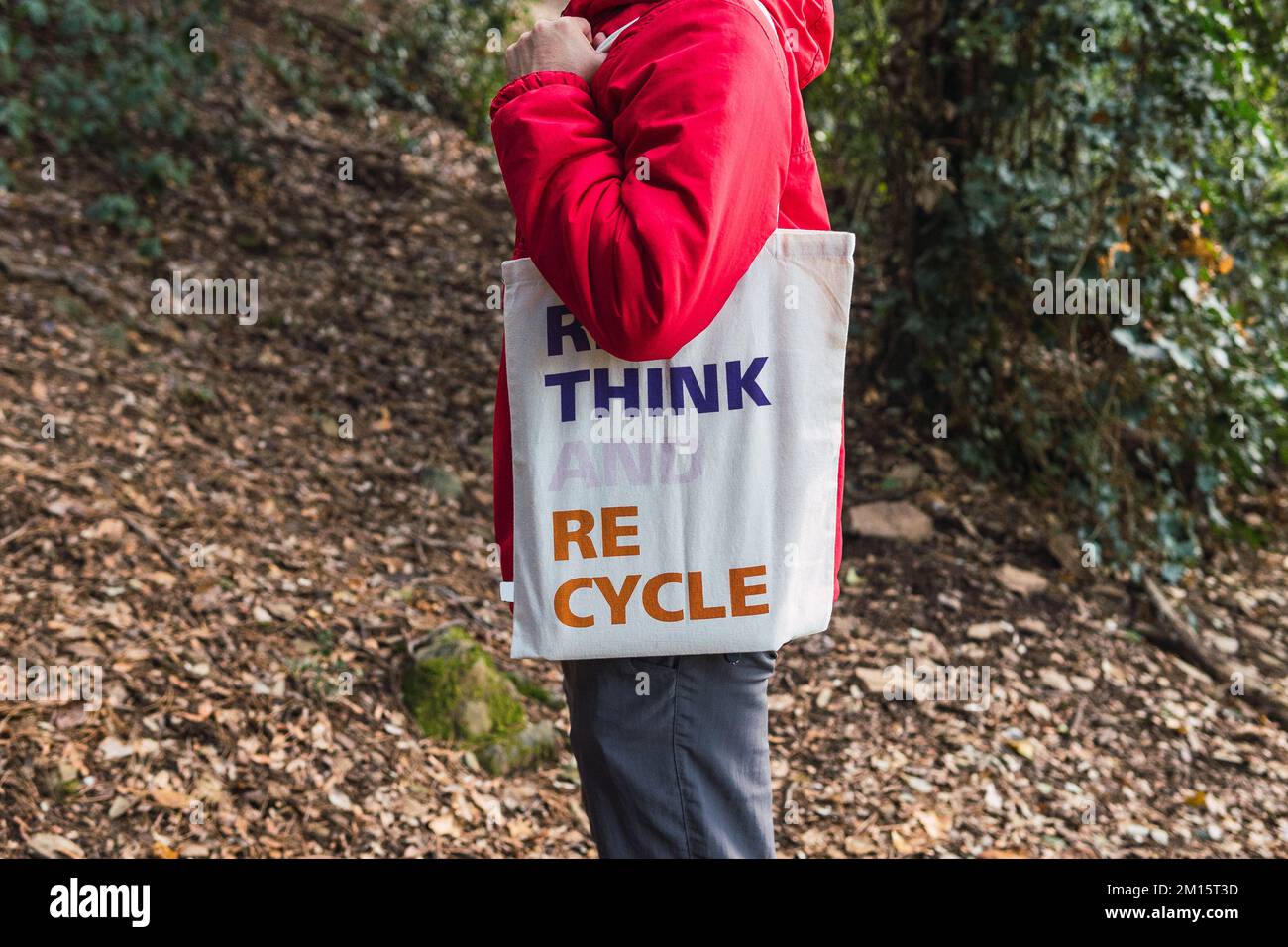 Side view of crop male traveler with cotton bag with Rethink Recycle inscription spending time in autumn woods Stock Photo