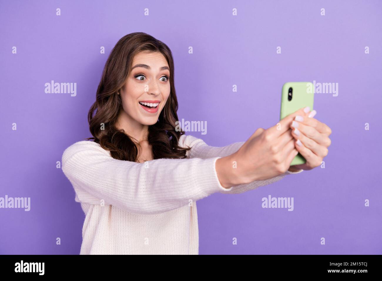 Photo of young excited funny face blogger take shot hold smartphone online stream twitch video recording isolated on violet color background Stock Photo