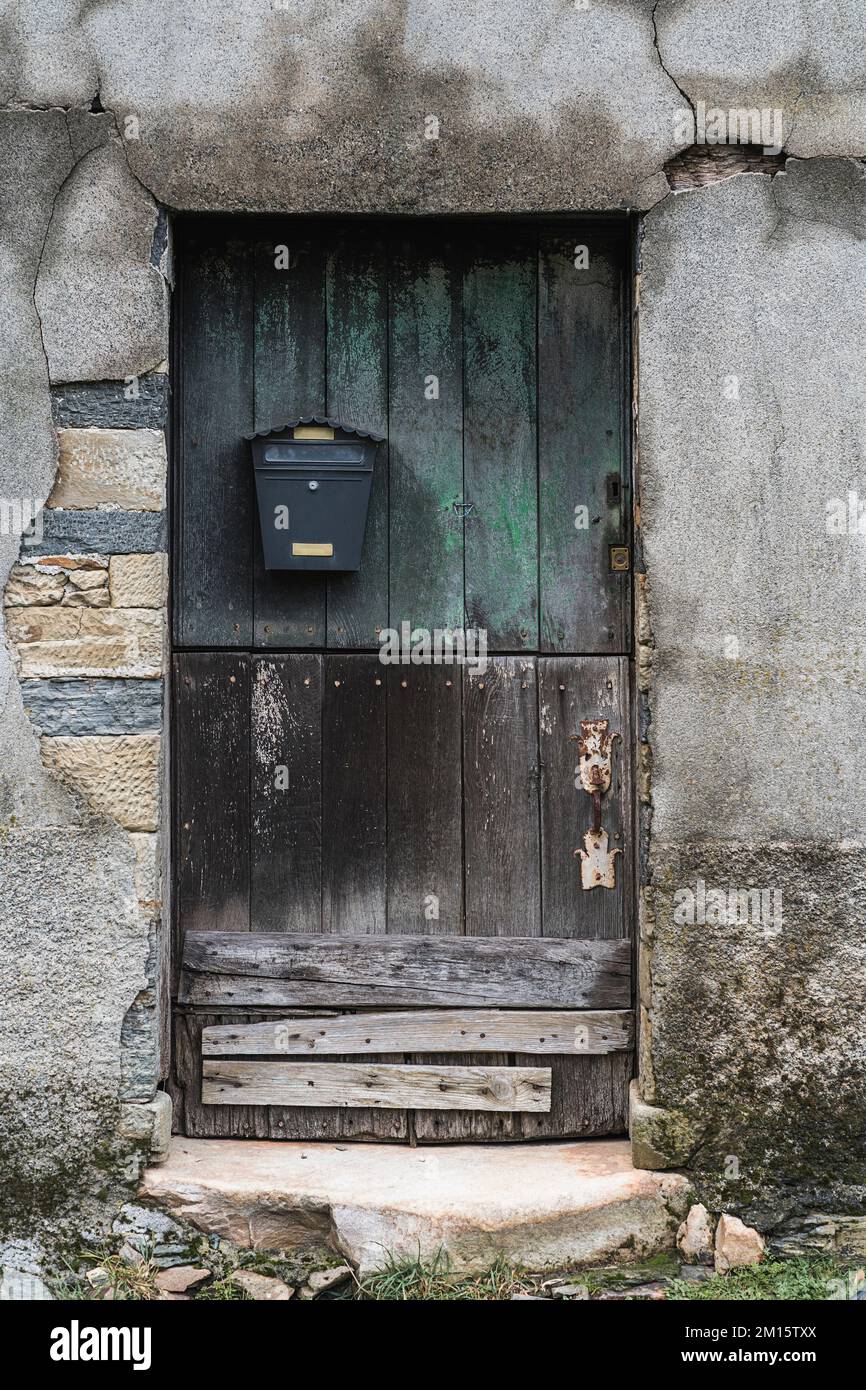 exterior-of-aged-stone-building-with-small-wooden-half-painted-door