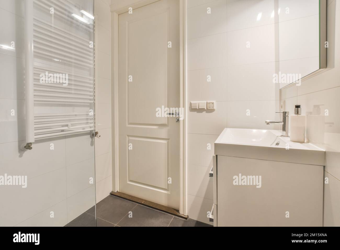 Mirror hanging over ceramic sink with chrome faucet in modern