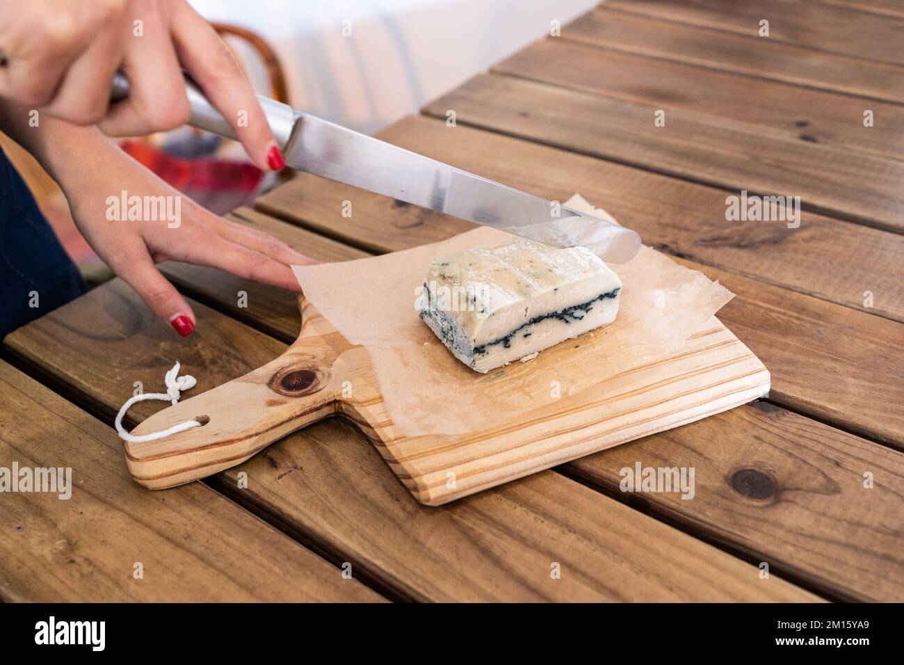 High angle of crop anonymous female cutting with knife bar of handmade