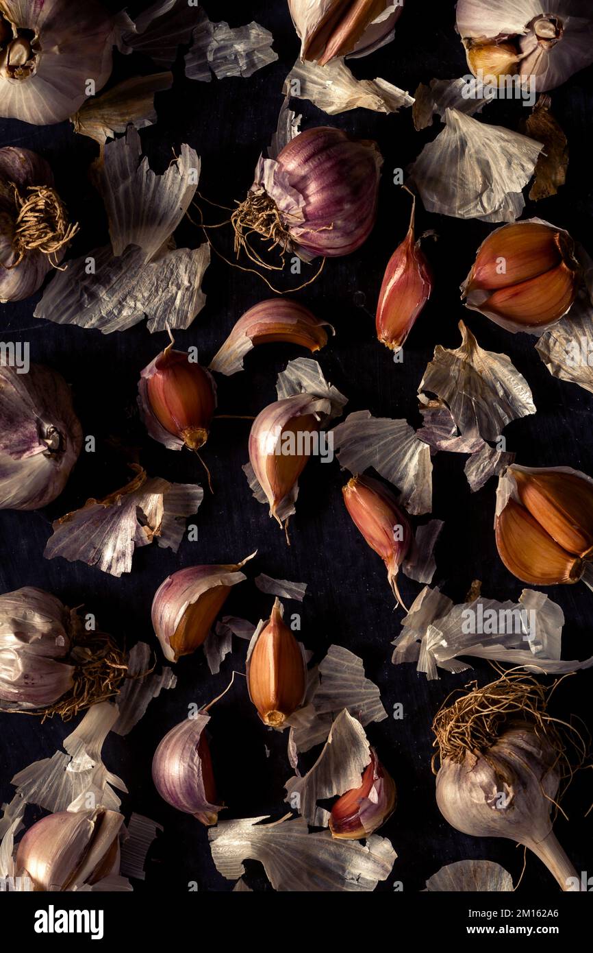 Fresh garlic bulbs and cloves grouped on black background. Flat lay ...