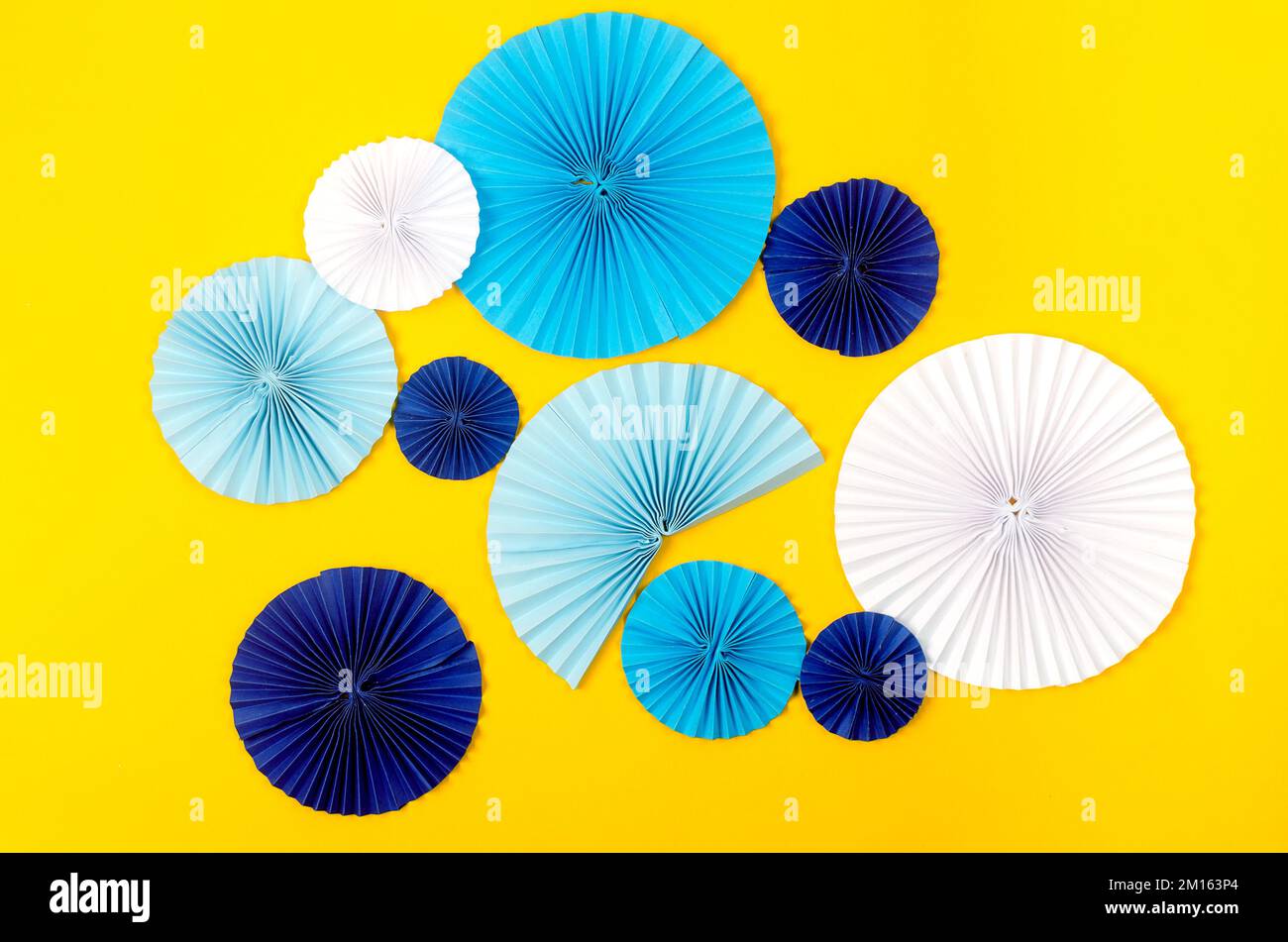 Blue paper fan medallion on yellow background. Holidays background