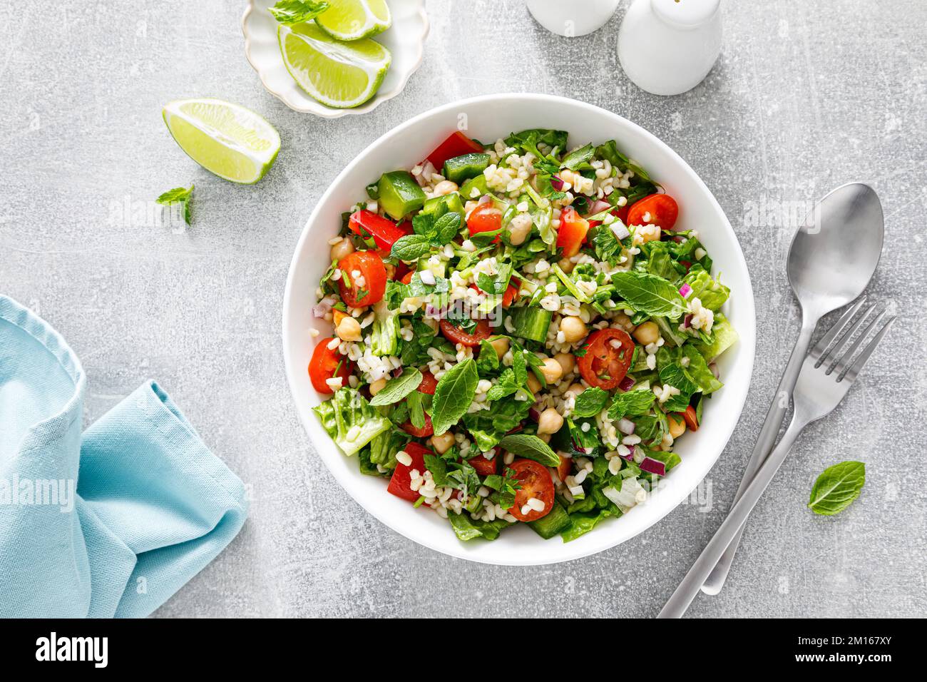 Tabbouleh salad. Tabouli salad with fresh parsley, onions, tomatoes, bulgur and chickpea. Healthy vegetarian food, mediterranean diet. Top view Stock Photo