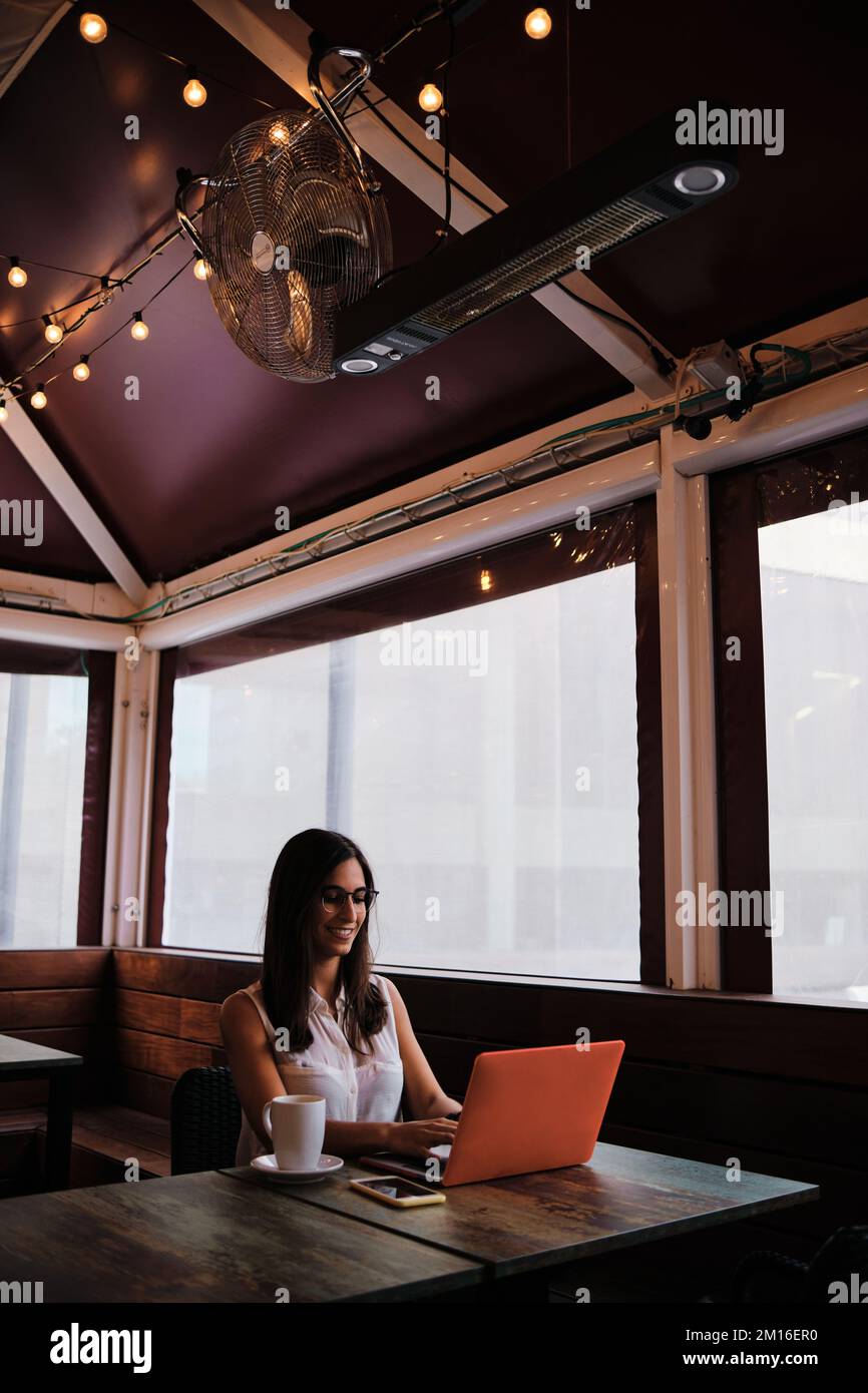 Vertical photo of a businesswoman working in a cafeteria Stock Photo