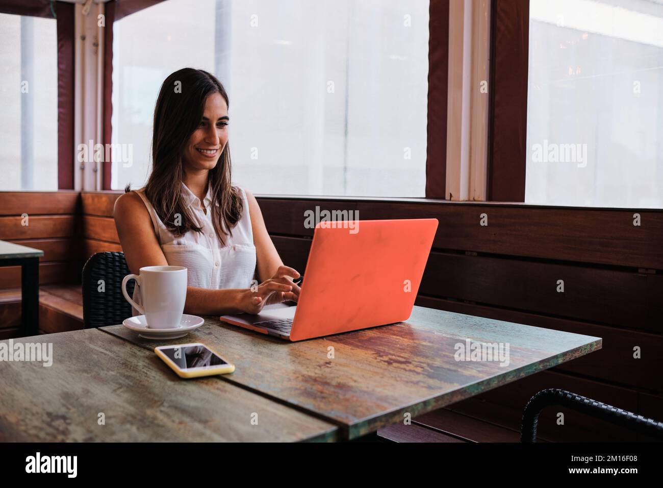 Cool businesswoman working with a laptop in a cafeteria Stock Photo