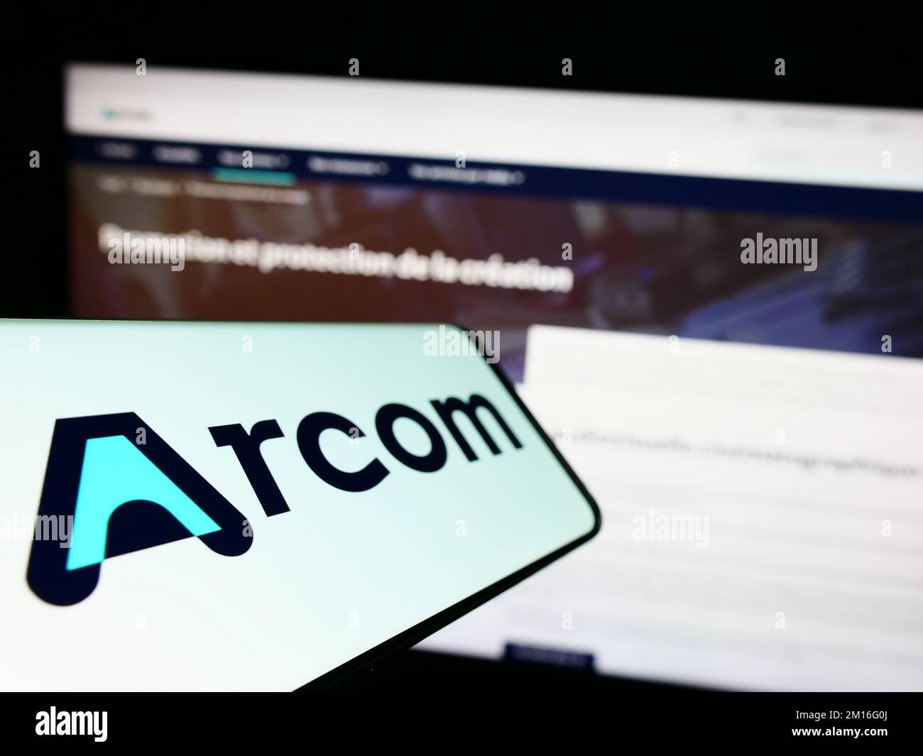 Mobile phone with logo of French digital regulation agency ARCOM on screen in front of business website. Focus on left of phone display. Stock Photo