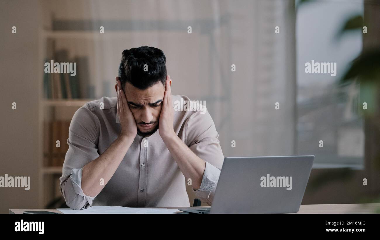 Frustrated young hispanic accountant male analyst business man feel stress check financial mistakes in report document analysis budget receive money p Stock Photo