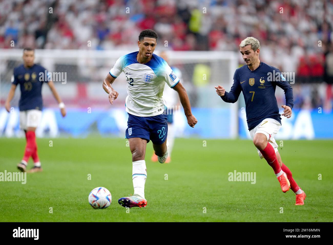 England's Jude Bellingham as France's Antoine Griezmann, (right) chases after him during the FIFA World Cup Quarter-Final match at the Al Bayt Stadium in Al Khor, Qatar. Picture date: Saturday December 10, 2022. Stock Photo