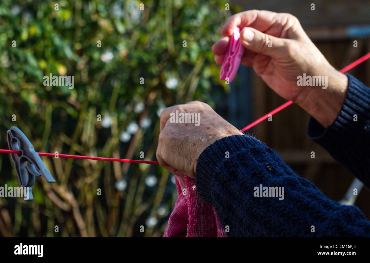 Close-up of an elderly mans hands pegging laundry Stock Photo