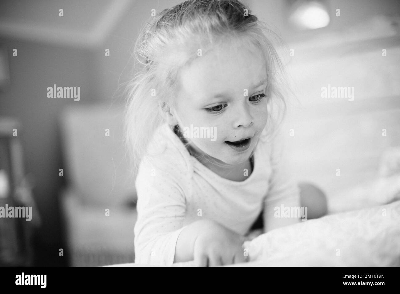 girl child waking up in the morning having fun and playing in bed Stock