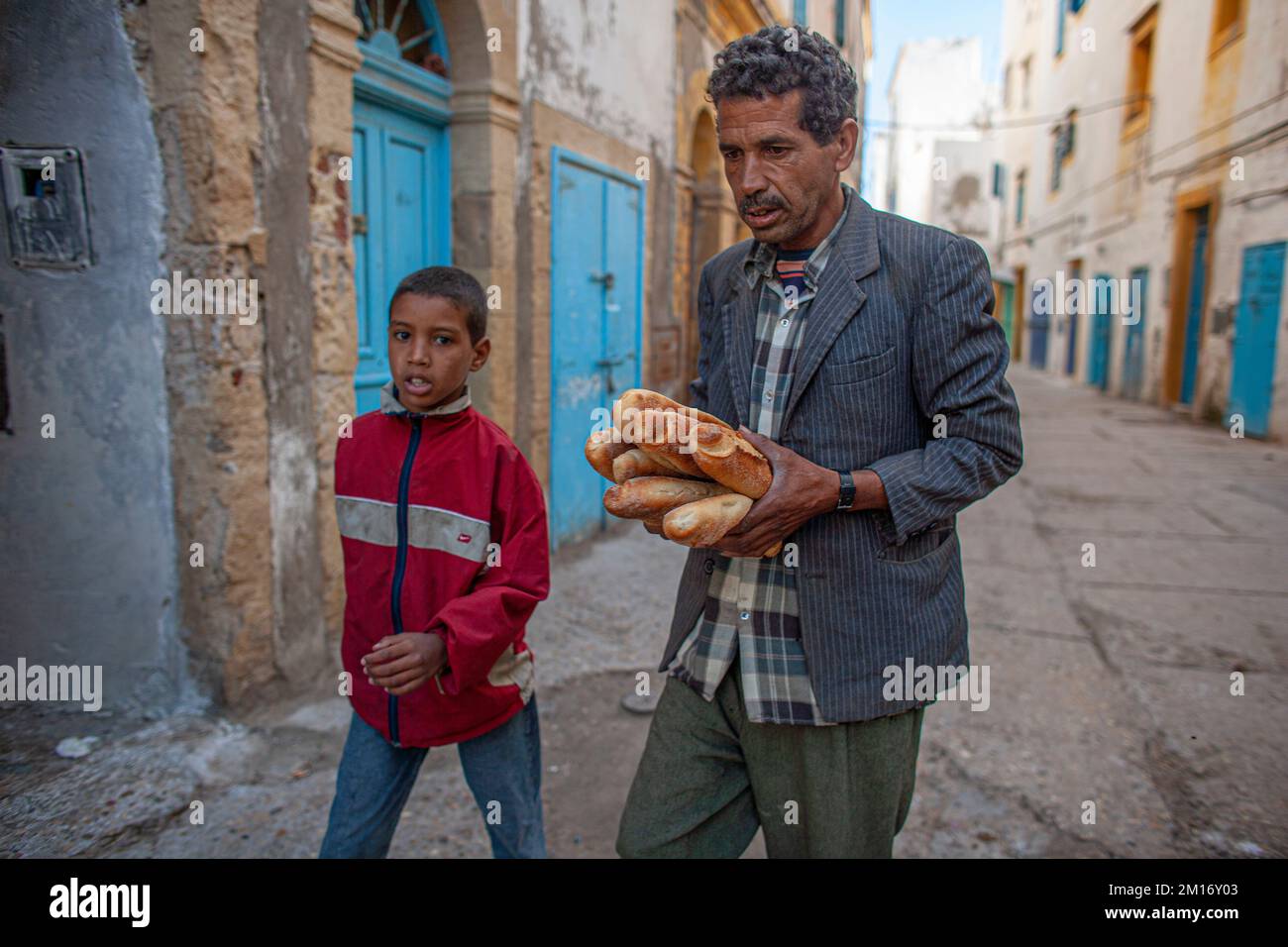 Street scene father and son carry baguettes in the Medina of Essaouira Morocco. Stock Photo