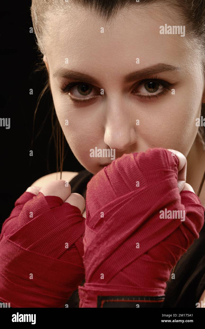 Muay Thai female boxer in attack pose. Fitness young woman boxing