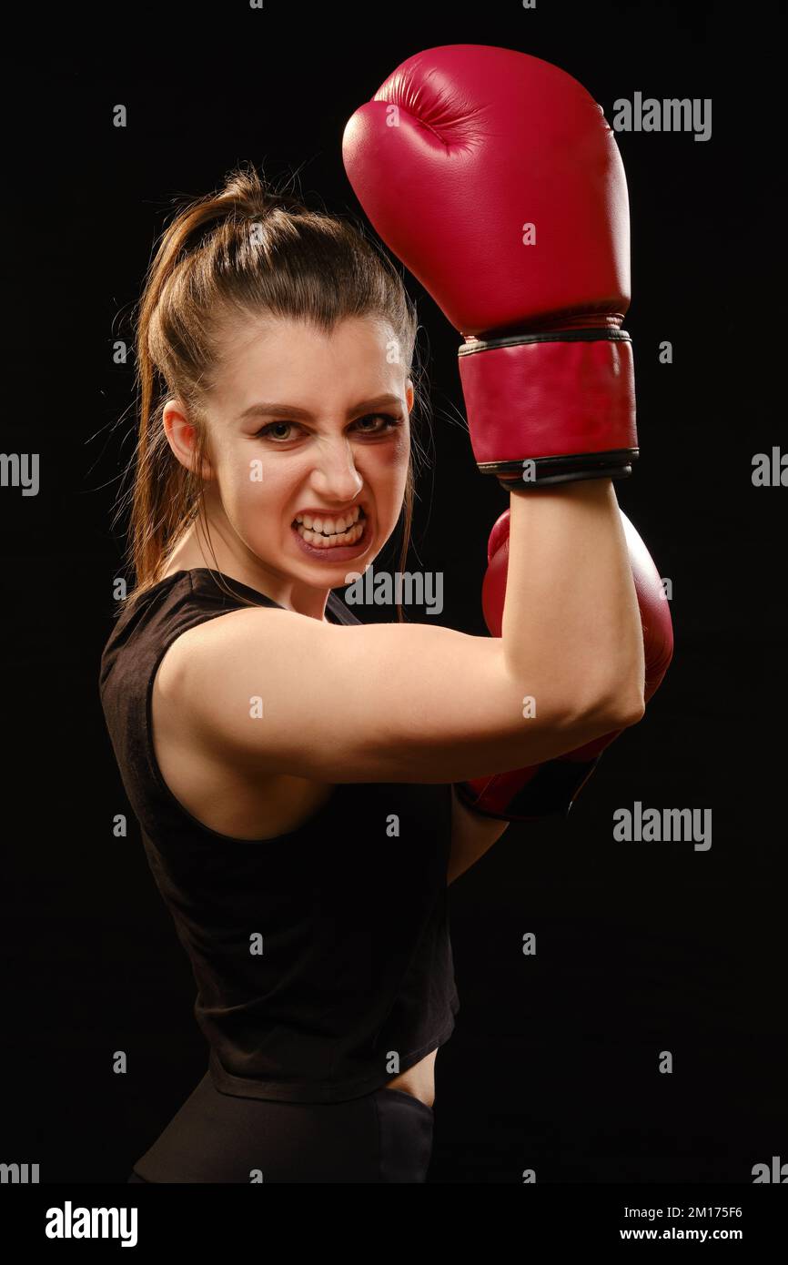 Pretty Muay Thai female boxer with bruise on face in attack pose