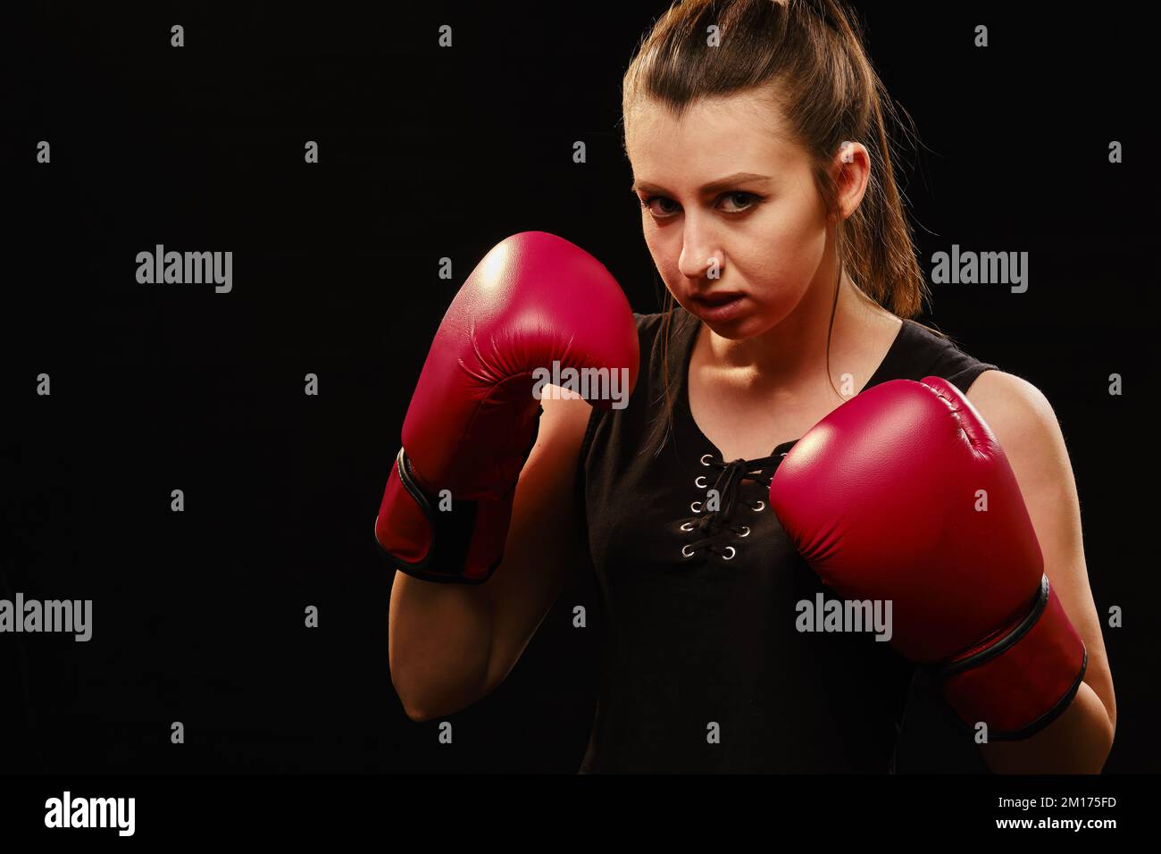 Muay Thai female boxer in attack pose. Fitness young woman boxing