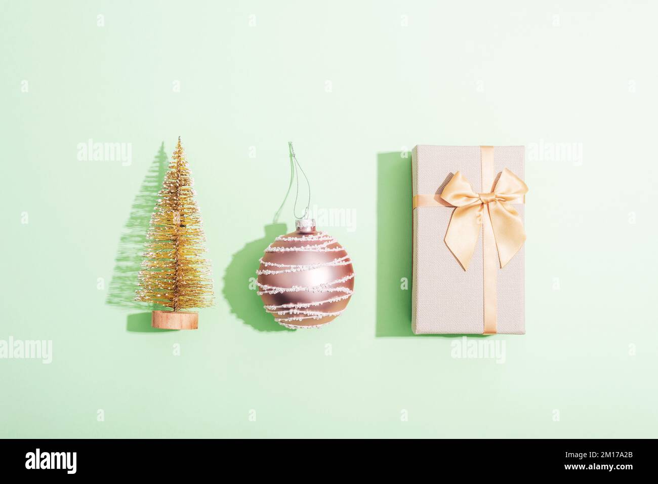 Gift box, Christmas ball and fir tree toy on green background with ...