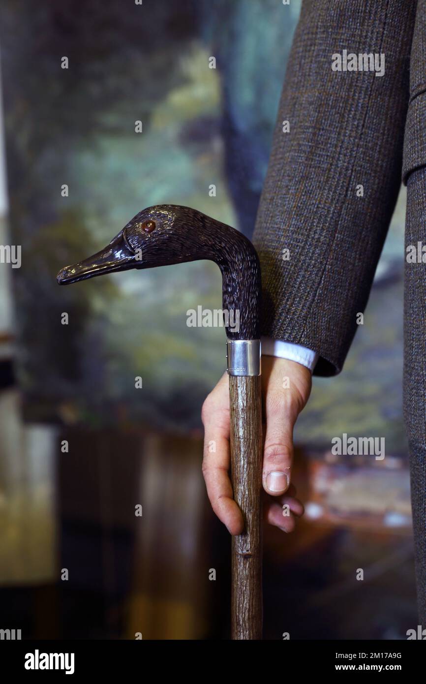 Close up of hand holding walking cane with duck's head handle Stock Photo