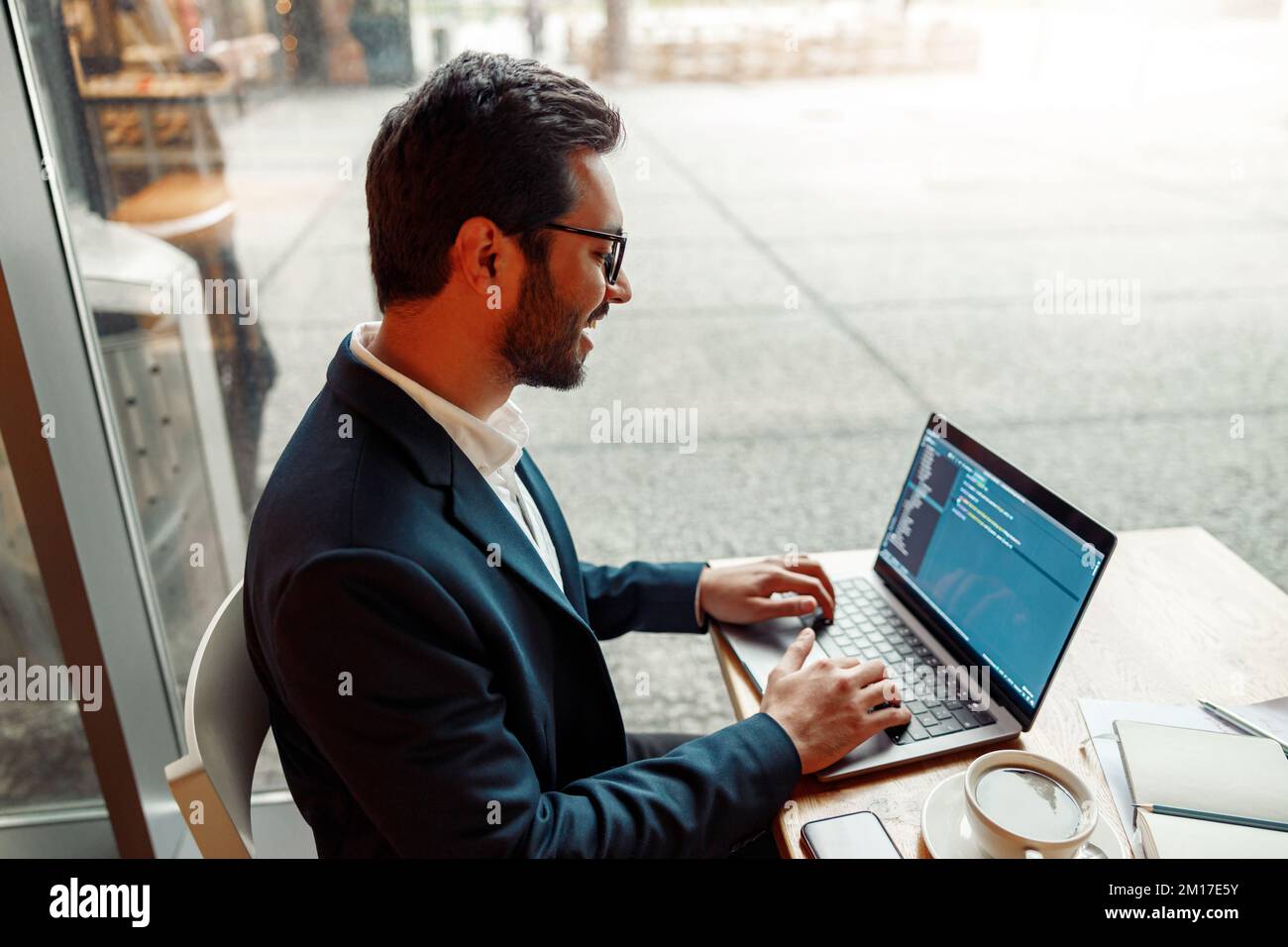 Handsome developer programmer freelancer in glasses working on project in cafe Stock Photo