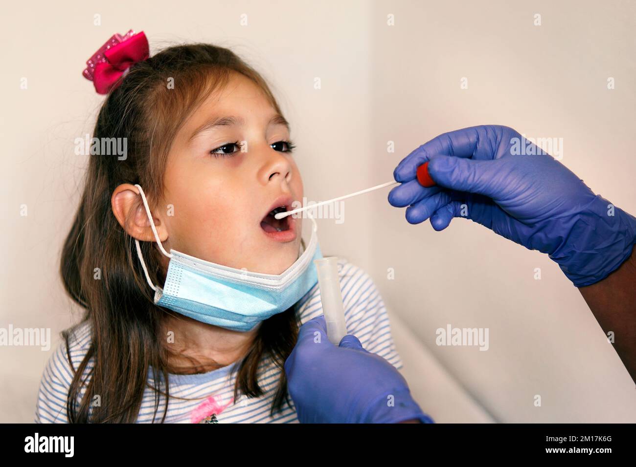 Doctor Doing Coronavirus covid 19 Test For girl Patient. Taking a saliva sample from a man. DNA test. Collection of mucus from the throat for research Stock Photo