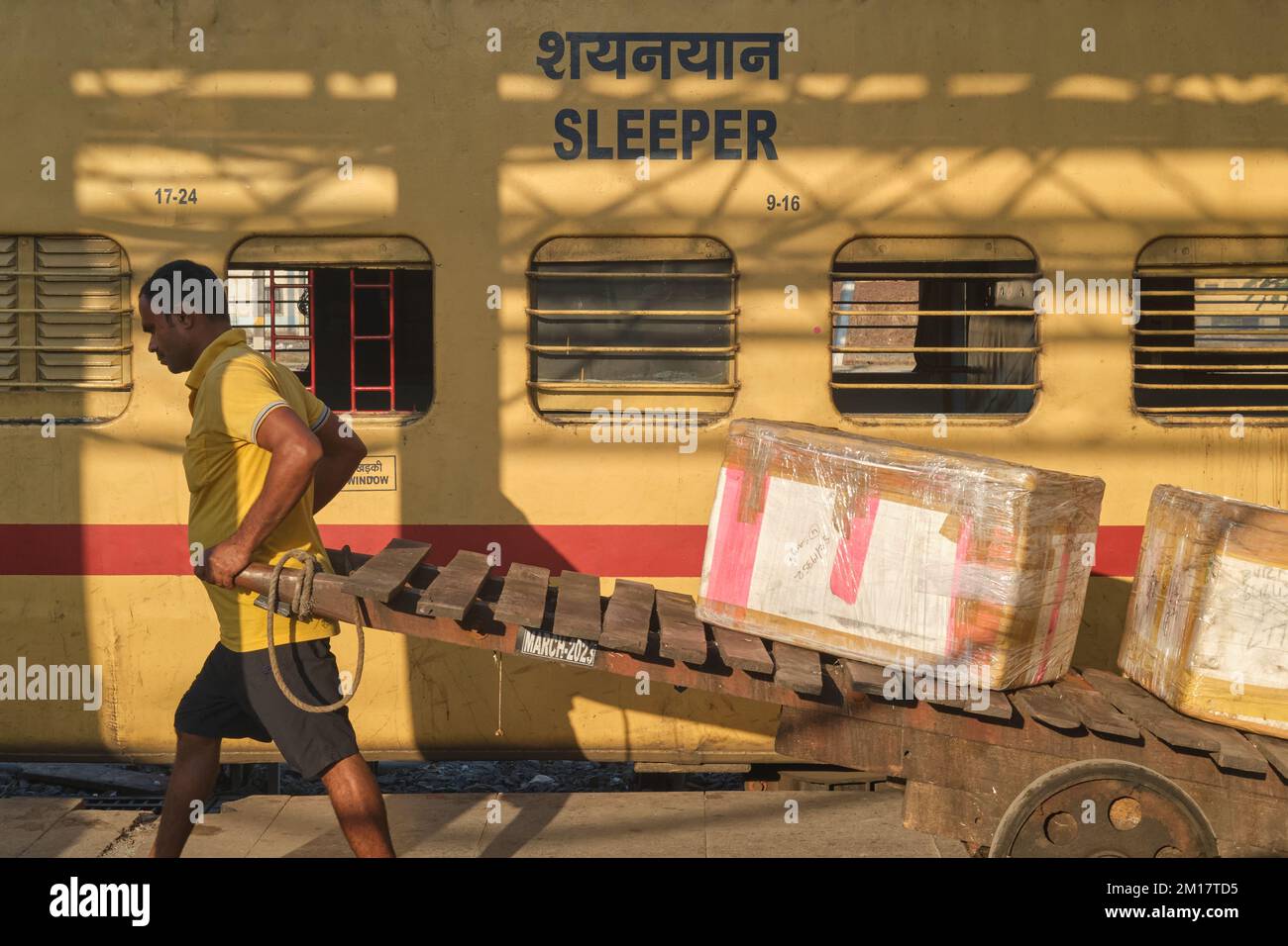 A porter with his trolley passing the sleeper carriage of a long