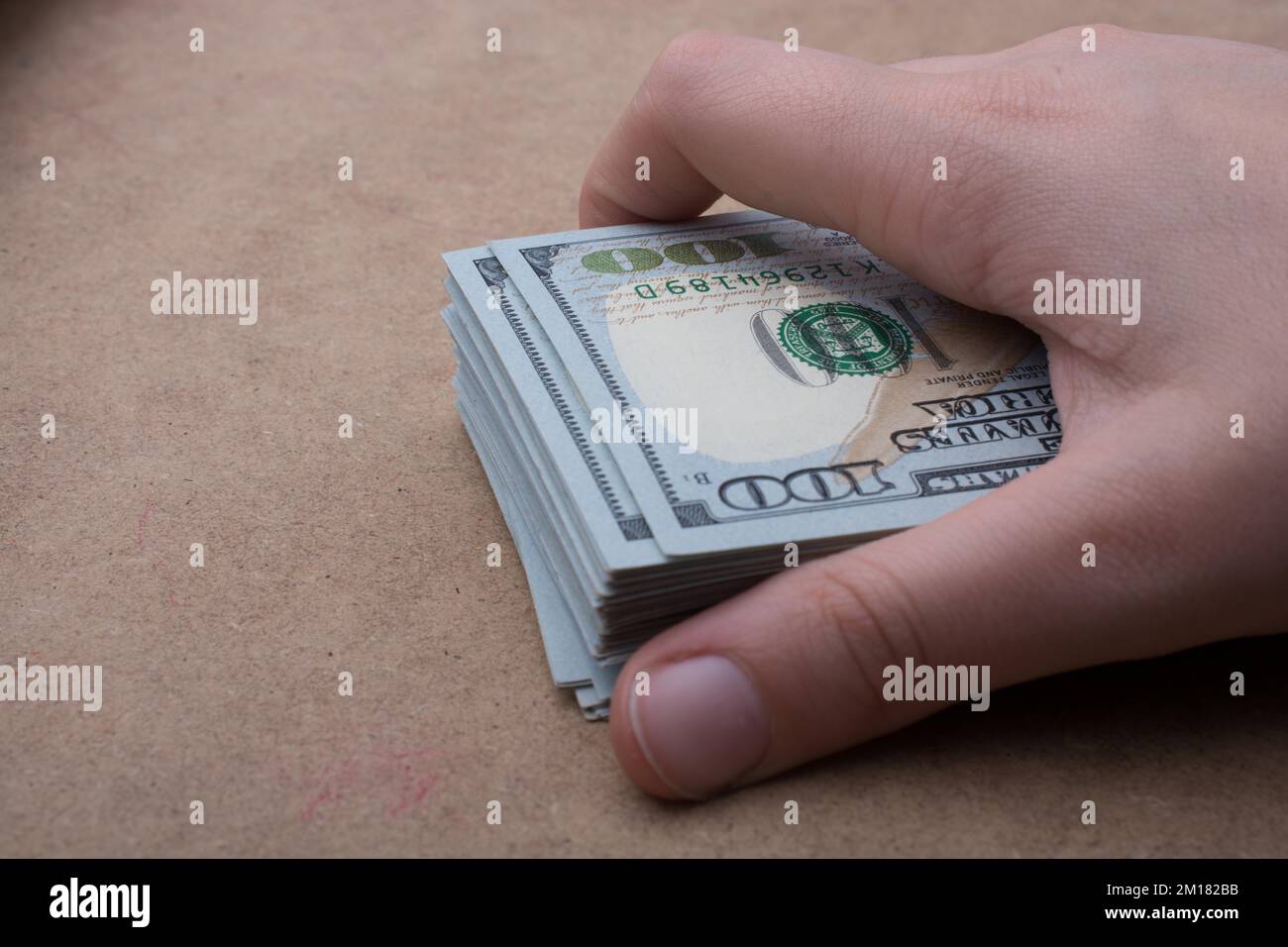 Hand holding banknote bundle of US dollar on a linen canvas background ...