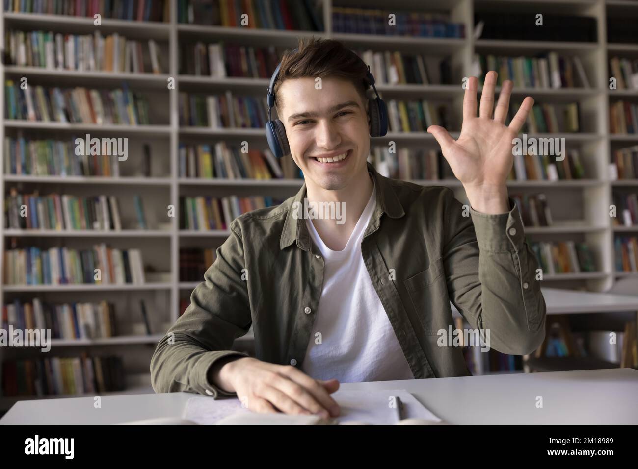 Cheerful handsome college guy in wireless headphones head shot portrait Stock Photo