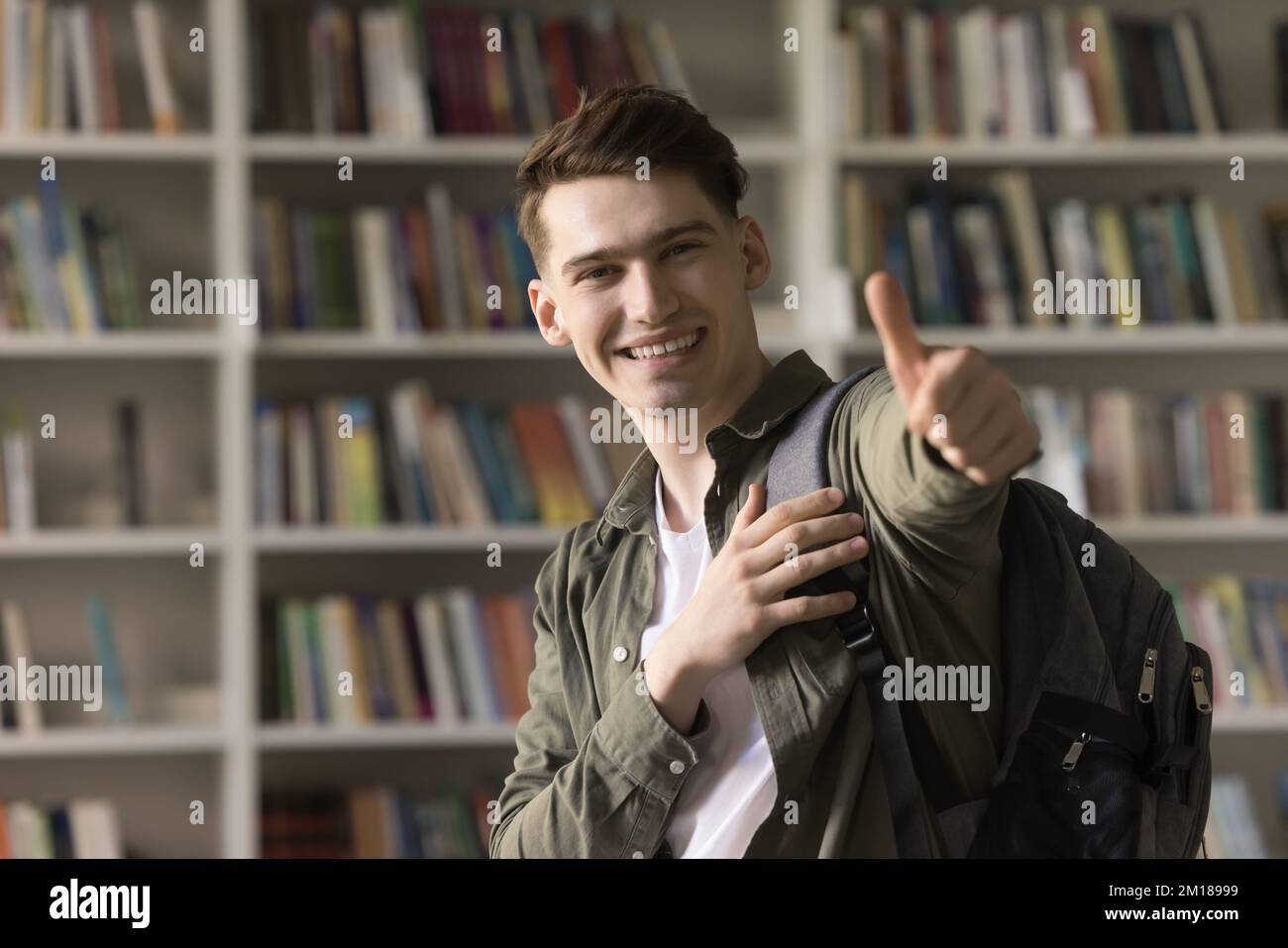 Cheerful satisfied handsome student guy recommending college Stock Photo