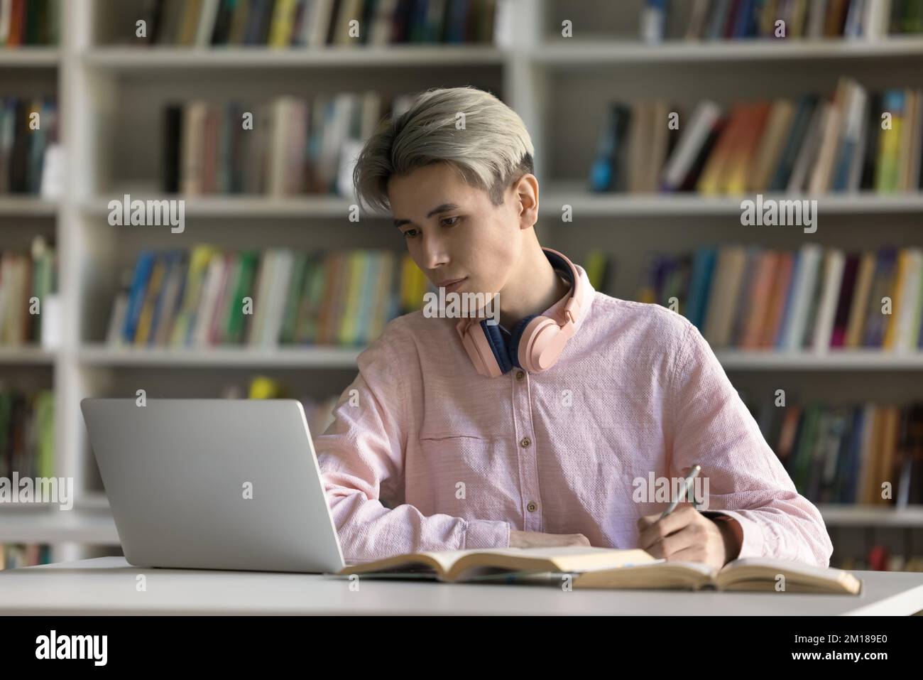 Serious Asian fresh male student watching learning webinar Stock Photo