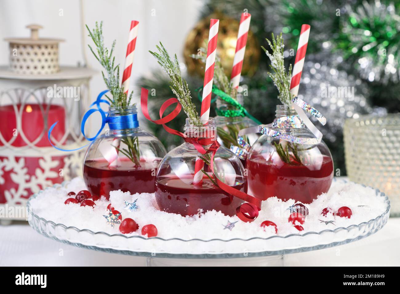 Gin with tonic and cranberry juice. The cocktail is full of festive Christmas flavors. Served in transparent bowls with a branch of rosemary. Stock Photo