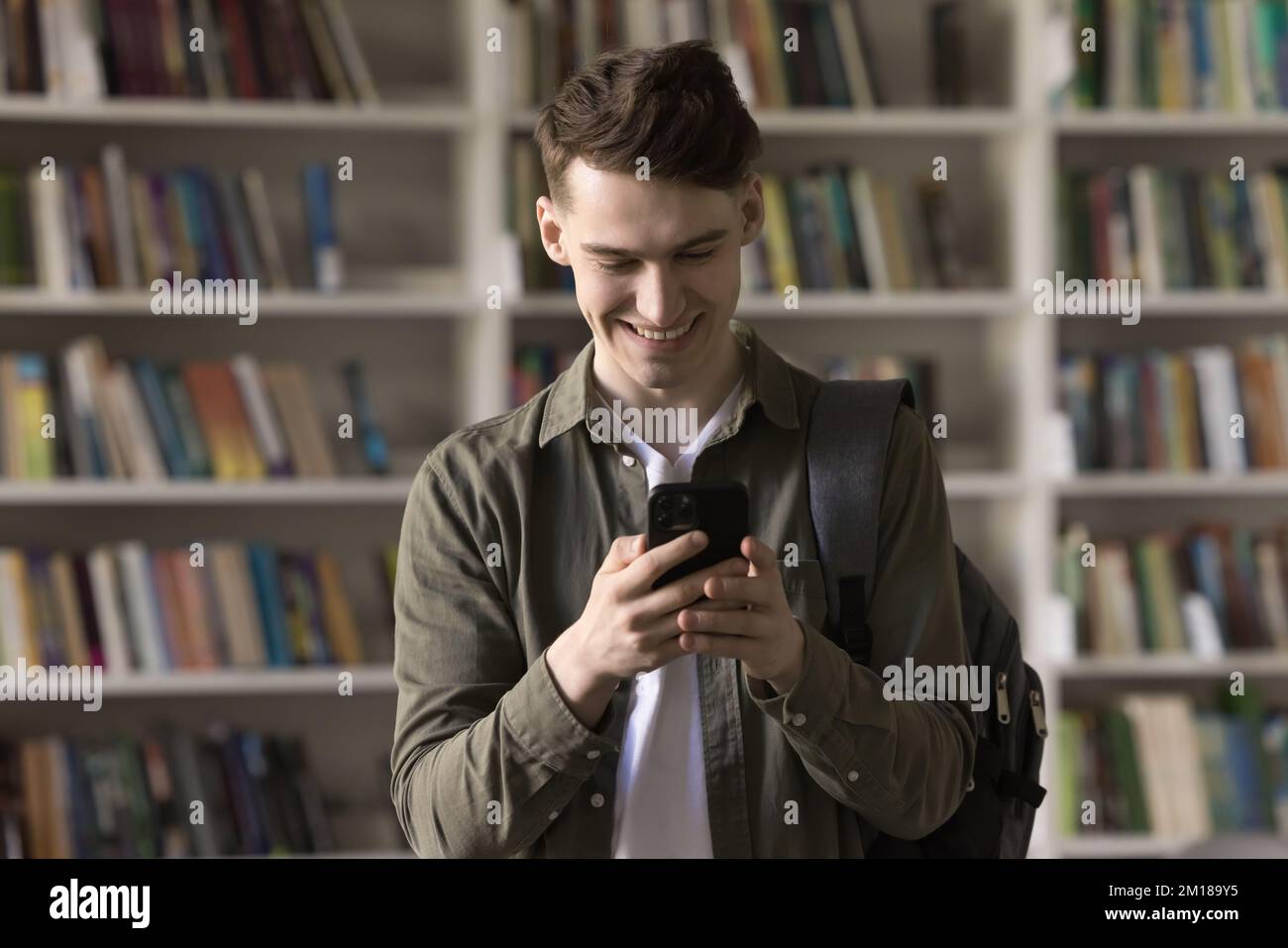 Happy student guy using learning application for study on smartphone Stock Photo