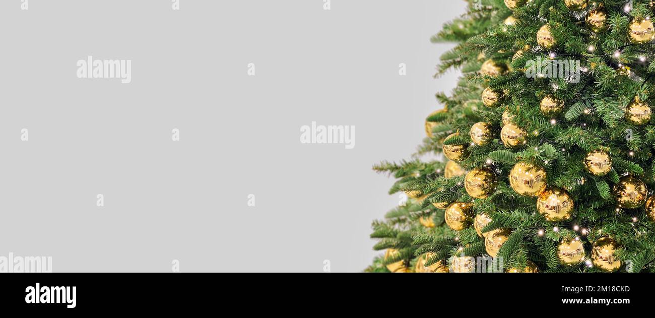 Christmas tree with golden ornaments lights. Long banner Stock Photo