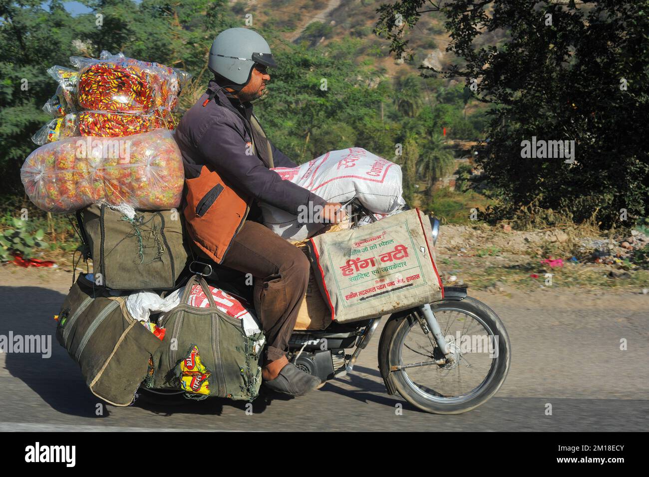Man transporting goods on an overloaded motorcycle. Jaipur, India Stock Photo