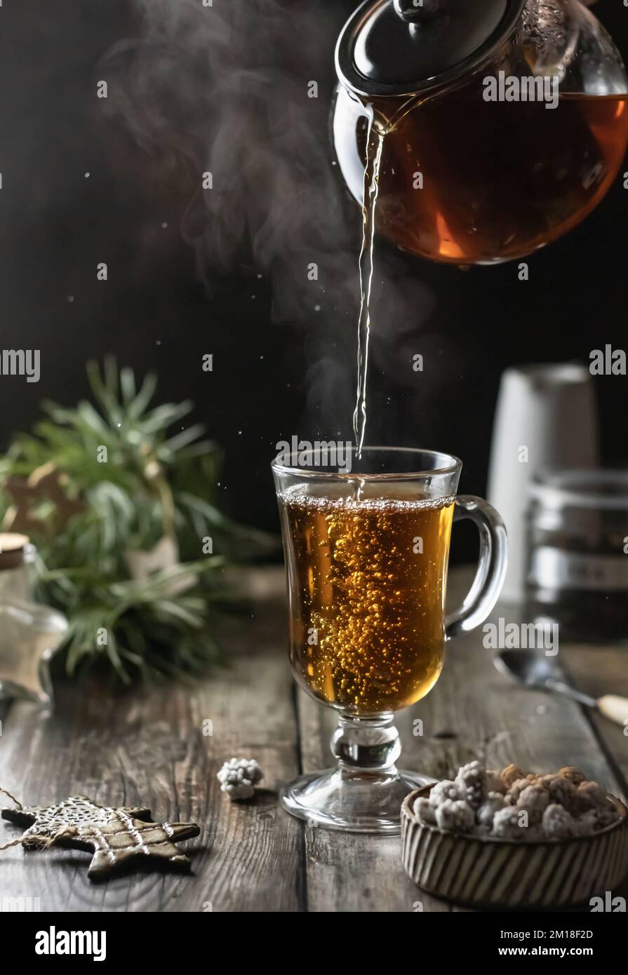 Tea is poured into a glass from a glass teapot, pouring process with ...
