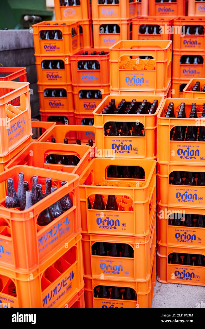 Orion beer crates, orange, with empty beer bottles; Okinawa, Japan Stock Photo