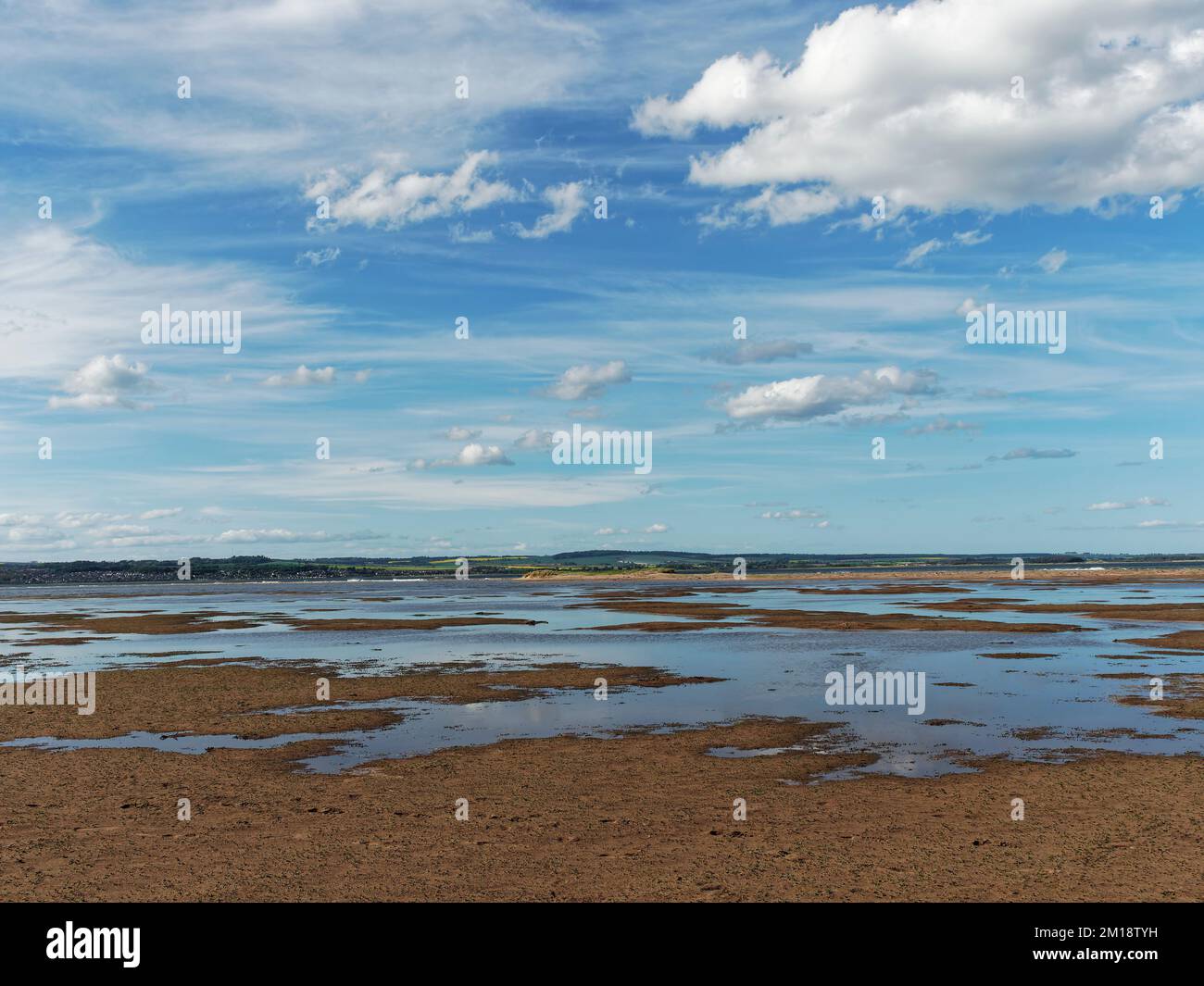 The pools and wet sand of the Headwell Sands at Tentsmuir Point with the town of Broughty Ferry in the Background. Stock Photo