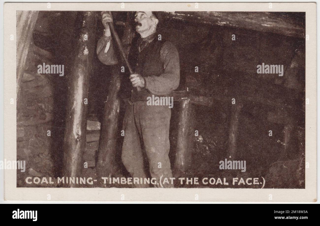 Coal mining - timbering at the coal face. Early 20th century photograph of a miner timbering or fitting wooden props to support the roof in the underground coal mine. The image was one of a set of photos published as postcards by M. Brookes of Pontypridd, South Wales Stock Photo