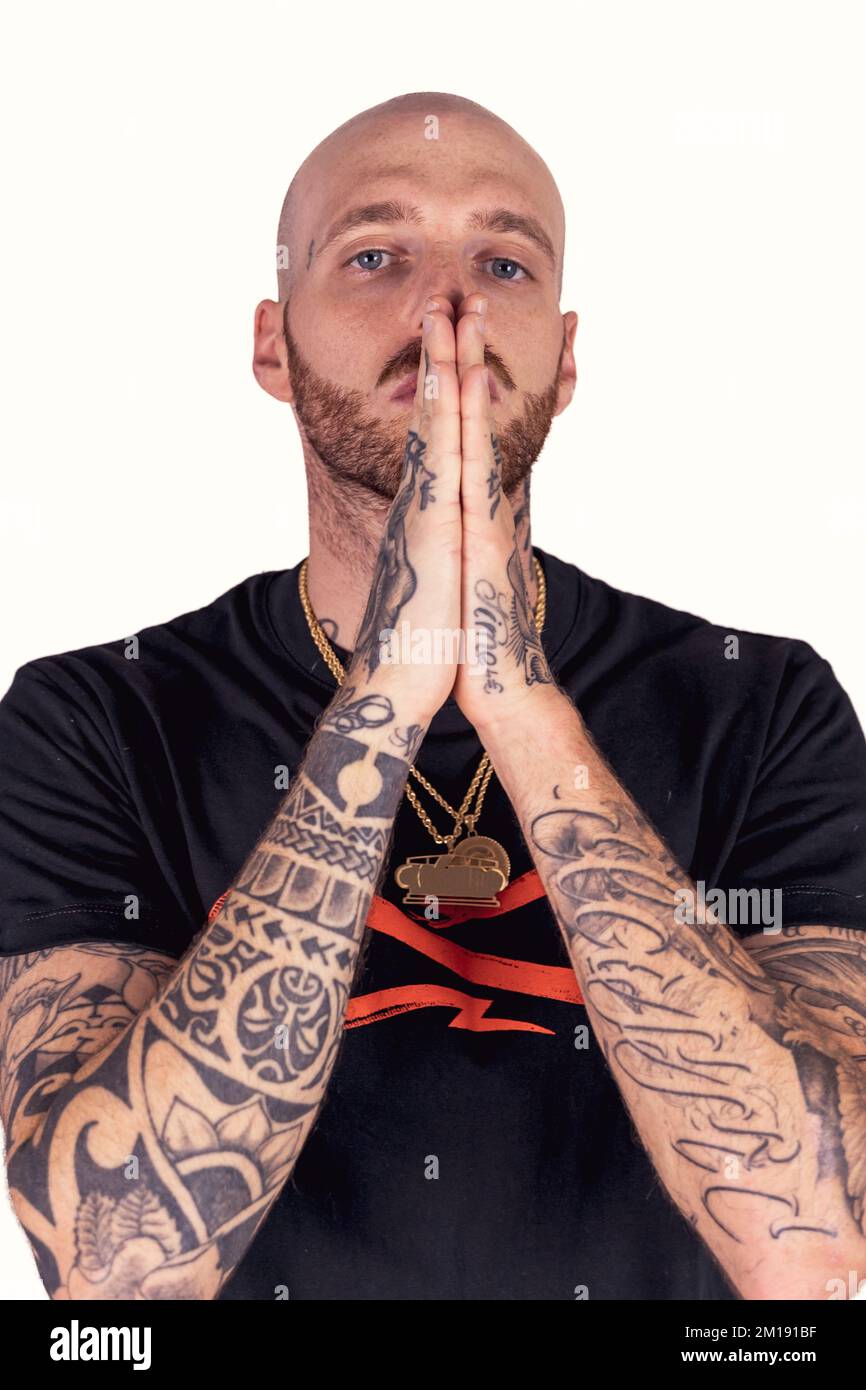 tattooed rap singer posing in studio wearing black clothes on a white ...