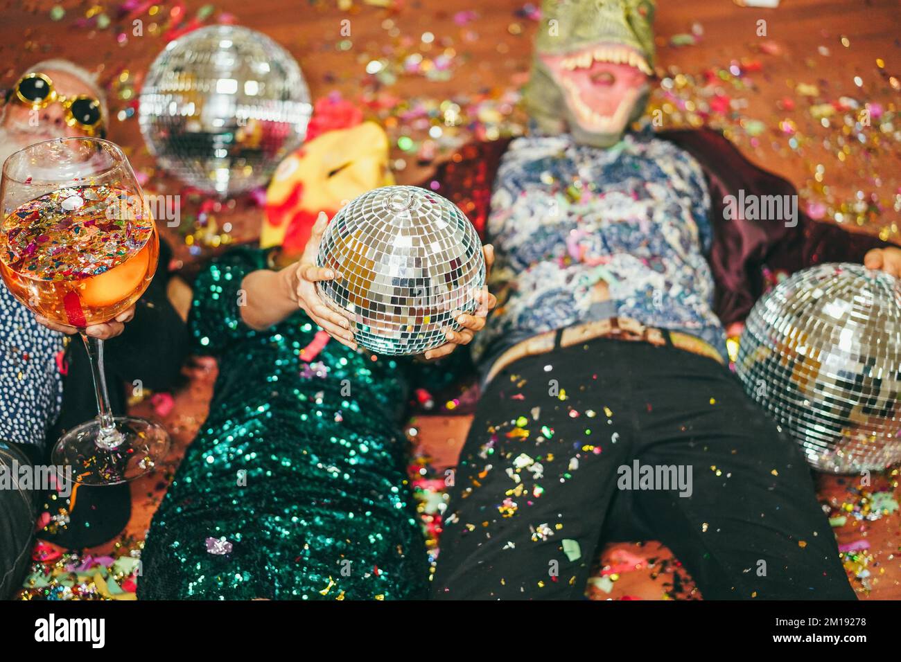 Crazy people celebrating carnival party inside nightclub - Focus on hands holding disco ball Stock Photo