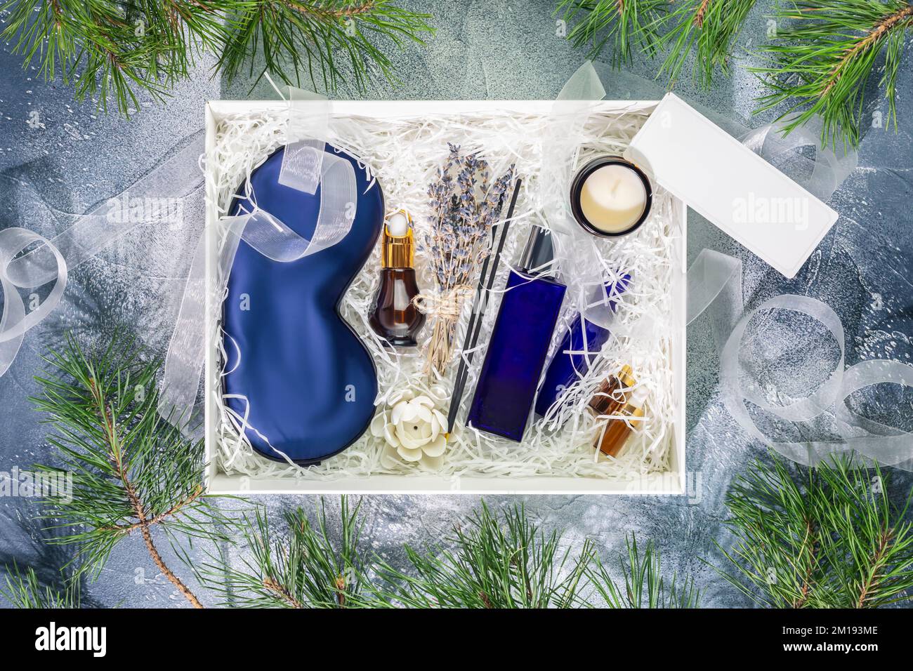 Men winter holidays gift box. Christmas or New Year White gift box with sleep care set for men. Preparing self care package, craft gift box with mask Stock Photo